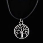 Person with tree of life necklace Australia Black color, front view, showing silver pendant.