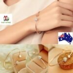 Person with gold cuff bracelet Australia Gold color, front view, showing rhinestone heart.
