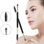 Person with dual eyebrow brush Australia Black color, front view, showing angled tip.