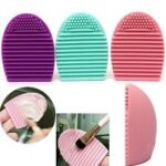Person with makeup brush scrubber Australia Green color, front view, showing silicone texture.