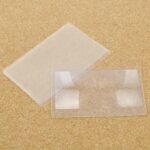 Person with credit card magnifier Australia Multi-color, front view, showing Fresnel lens.