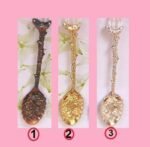 Person with retro fruit spoon Australia Silver/Gold/Copper color, front view, showing elegant design.