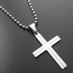 Person with cross necklace Australia Silver color, front view, showing cross pendant.
