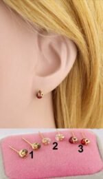 Person with zircon stud earrings Australia Gold color, front view, showing zircon stones.