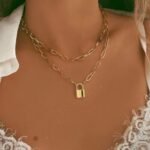 Person with lock pendant necklace Australia Gold color, front view, showing lock pendant.