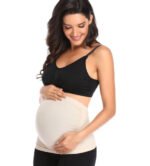 Pregnant woman in breathable maternity support belt Black color, front view, showing stretchy fit.