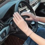 Woman in UV protection driving gloves Pink color, front view, showing cotton mesh design.