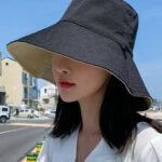 Woman in foldable UV bucket hat Blue color, front view, showing wide brim.