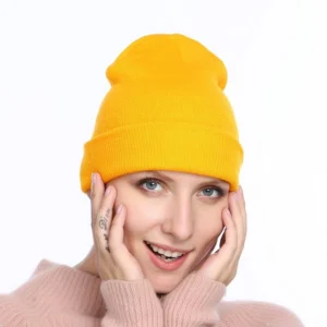Person in acrylic winter beanie hat Grey color, front view, showing knitted design.