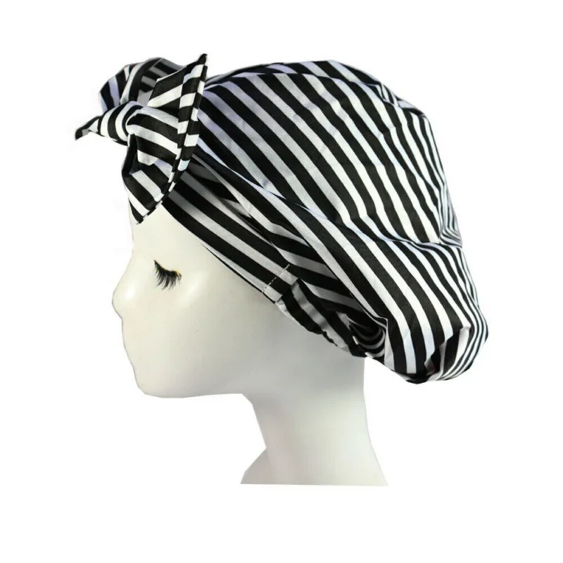 Woman using reusable turban shower cap Tropical Leaf color, front view, showing bow design.