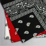 Person in paisley cotton bandana Australia Black color, front view, showing paisley design.