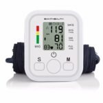 Person with upper arm blood pressure monitor Australia Shown color, front view, showing LCD screen.