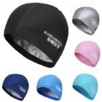 Person with waterproof swim cap Australia Blue color, front view, showing ear protection.