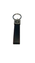 Black Nissan leather keychain with carbon effect and logo, attached to car keys.