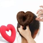A heart shape tiaras hair tool shaping a girl’s bun.