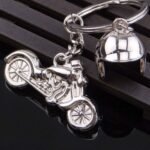 Silver motorcycle helmet keychain attached to a bike key ring.