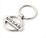 Silver Nissan badge keyring Australia with logo pendant on a car key.